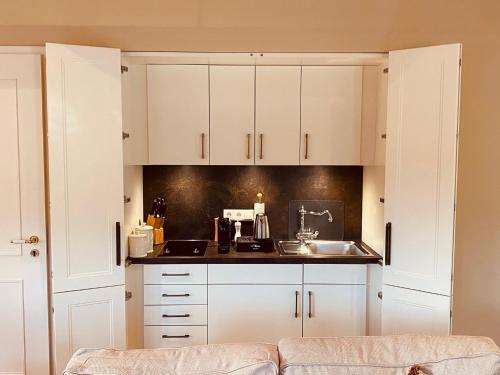 a kitchen with white cabinets and a sink at Landhaus Eggert in Münster