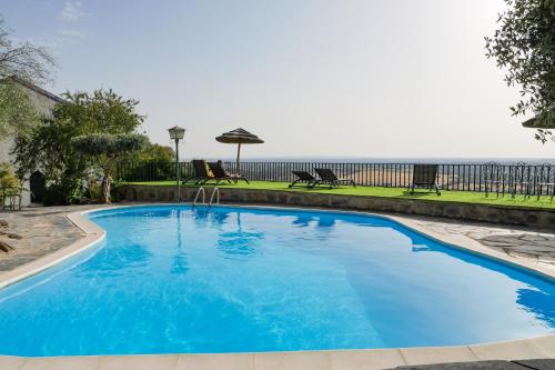 a large blue swimming pool with the ocean in the background at Estalagem de Monsaraz in Monsaraz
