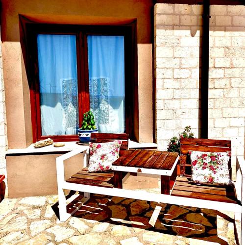 two wooden benches sitting in front of a window at Antica Masseria Il Casone in Candela