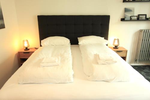 a bedroom with two beds with white sheets and pillows at Day Dream L23 Guesthouse in Reykjavík