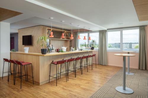 a kitchen with a bar with stools at Hyatt House Paris Charles de Gaulle Airport in Roissy-en-France