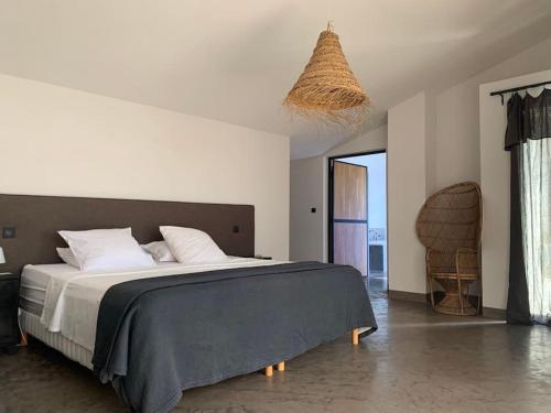 ein Schlafzimmer mit einem großen Bett und einem Stuhl in der Unterkunft Calme et confort dans un écrin de verdure in Montferrier-sur-Lez