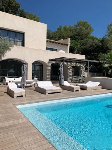 une piscine avec des chaises longues et un bâtiment dans l'établissement Calme et confort dans un écrin de verdure, à Montferrier-sur-Lez