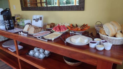 a table with a bunch of different types of bread at Pousada São Miguel in Cunha