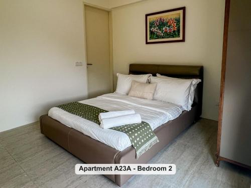 a small bedroom with a bed with white sheets and pillows at By the Sea- Pool and Sea View in Batu Ferringhi