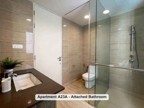 a bathroom with a shower and a sink and a toilet at By the Sea- Pool and Sea View in Batu Ferringhi