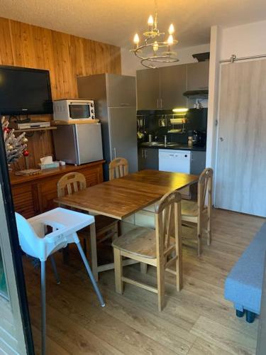 - une cuisine avec une table et des chaises en bois dans l'établissement Studio-4 Personnes Les Orres 1650-Hautes alpes, à Le Mélézet