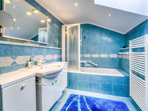 a blue bathroom with a sink and a tub at Villa Mona Lisa Lovran - Croatia in Lovran