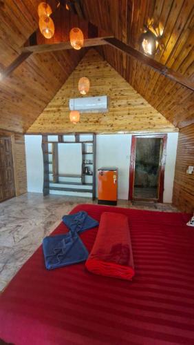 a large bed in a room with a red blanket at Mai Pen Rai Bungalows in Than Sadet Beach