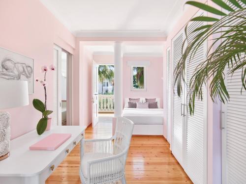 a home office with a white desk and a plant at Mandola Rosa at Riviera Olympia, A Grecotel Resort to Live in Loutra Killinis