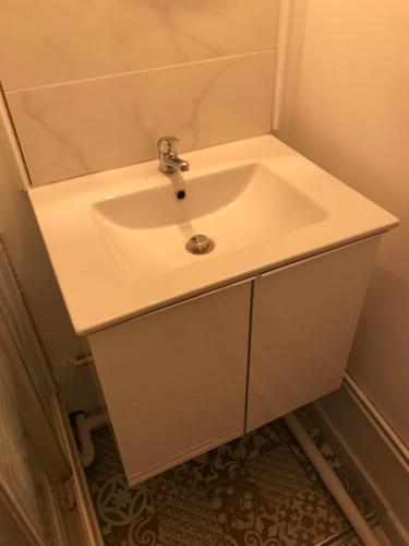 La salle de bains est pourvue d'un lavabo blanc. dans l'établissement Studio cosy, à Metz