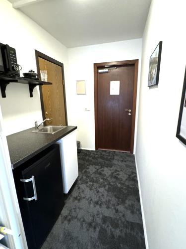 a small kitchen with a sink and a door at Day Dream L23 Guesthouse in Reykjavík