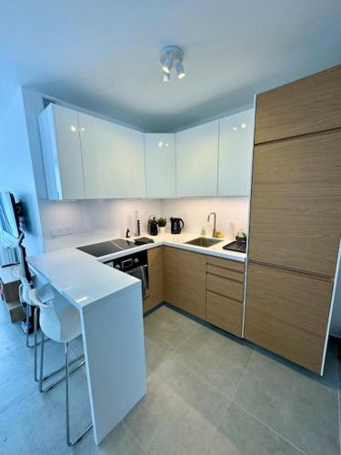 une cuisine avec des armoires blanches et une table blanche dans l'établissement Newly refurbished modern studio, à Paris