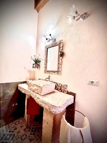 a bathroom with a sink and a mirror on the wall at Antica Masseria Il Casone in Candela