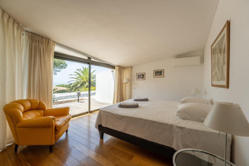 une chambre avec un lit, une chaise et une fenêtre dans l'établissement Mont Saint-Clair vue mer et étang, piscine et Clim, à Sète