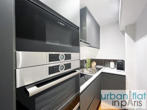 une cuisine avec un micro-ondes et une cuisinière four supérieur dans l'établissement Urban Flat 168 - Spacious 1-Bedroom Apartment in Paris, à Paris