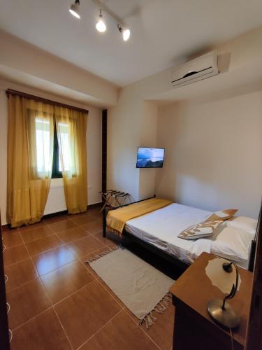 a bedroom with two beds and a desk and a tv at Casa Katerina 1892 in Poros