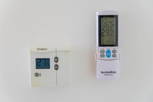 an electronic thermometer is next to a white box at Flexible SelfCheckIns 93 - Zagreb - Garage - Balcony - Bedroom in Zagreb