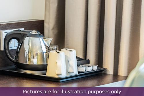 a tea kettle and towels on a tray on a table at Premier Inn Köln City Centre in Cologne