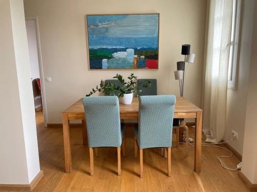 - une table à manger avec 2 chaises et une plante dans l'établissement APPARTEMENT BOULOGNE BILLANCOURT TOUT PRES de ROLAND GARROS, à Boulogne-Billancourt