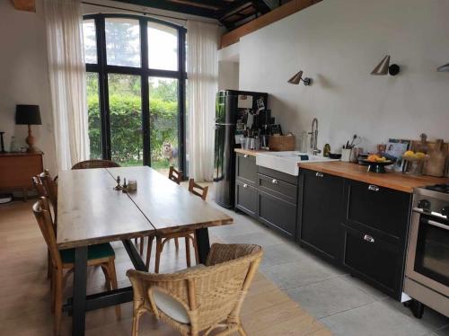 une cuisine avec une table en bois et une salle à manger dans l'établissement L' Authentique - Longère de caractère rénovée, à Vault-de-Lugny