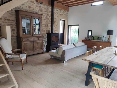 un salon avec un canapé et une table dans l'établissement L' Authentique - Longère de caractère rénovée, à Vault-de-Lugny