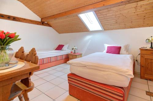 a bedroom with two beds and a table with flowers at Apartment Landhotel Zum Storchennest in Bann