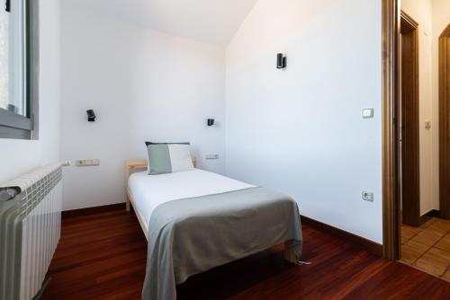 a small bedroom with a bed in a room at Casona Playa By Limens in Hio