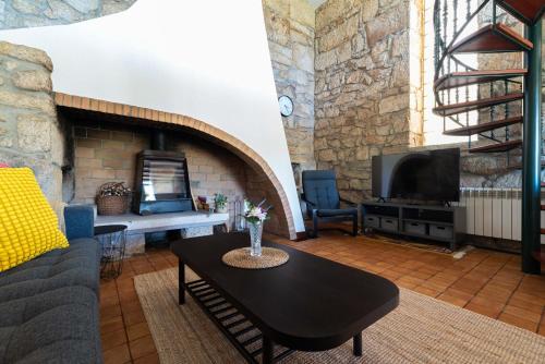 a living room with a couch and a table and a fireplace at Casona Playa By Limens in Hio