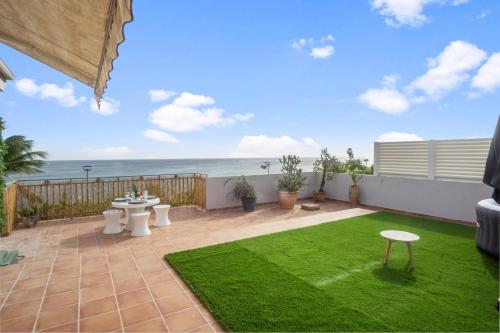 a patio with a lawn and the ocean in the background at Appartement Bourg de Schoelcher - Rooftop in Schœlcher