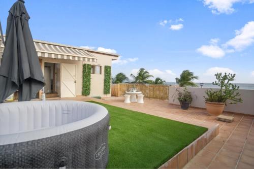 a backyard with a lawn and an umbrella at Appartement Bourg de Schoelcher - Rooftop in Schœlcher