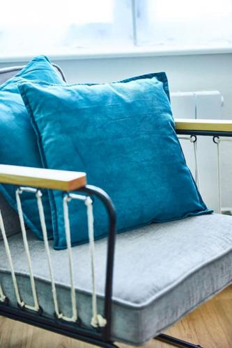 - un canapé avec des oreillers bleus dans l'établissement BM-3 Appartement au 3ème étage - F2 - 1 à 4 pers, à Mulhouse