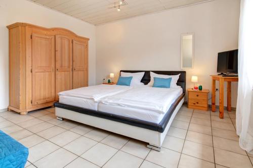a bedroom with a large bed with blue pillows at Apartment Landhotel Zum Storchennest in Bann