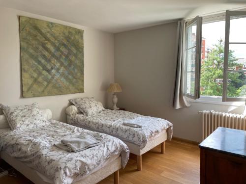 une chambre avec deux lits et deux fenêtres dans l'établissement APPARTEMENT BOULOGNE BILLANCOURT TOUT PRES de ROLAND GARROS, à Boulogne-Billancourt