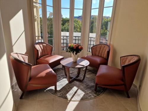 a waiting room with chairs and a table with a vase of flowers at Résidence Aston la Scala in Nice