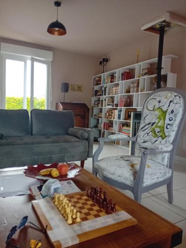 - un salon avec un canapé et un échiquier sur une table dans l'établissement Charmilles a 2km plage, à Flocques