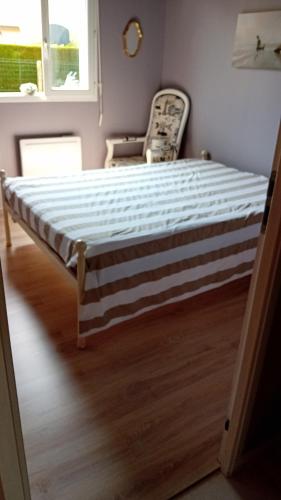 un cadre de lit dans une chambre avec une chaise dans l'établissement Charmilles a 2km plage, à Flocques