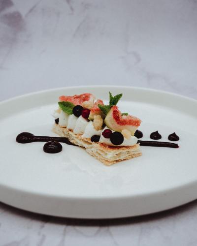 a white plate with a piece of dessert on it at Österreichischer Hof-im Bademantel direkt in die Alpentherme in Bad Hofgastein