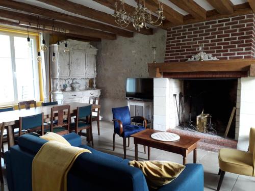un salon avec un canapé bleu et une cheminée dans l'établissement La Longère du Lavoir, à Dierre