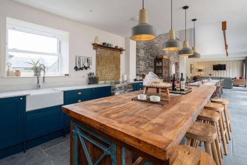 a kitchen with a large wooden table and blue cabinets at The Big Barn in Kidwelly