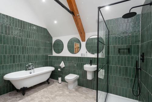 a bathroom with a tub and a toilet and a sink at The Big Barn in Kidwelly