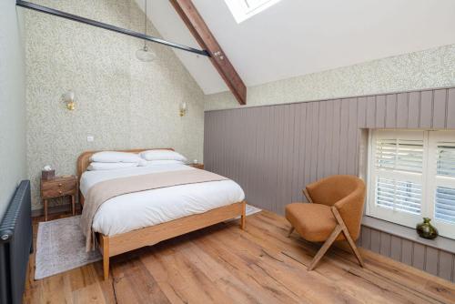 a bedroom with a bed and a chair at The Big Barn in Kidwelly