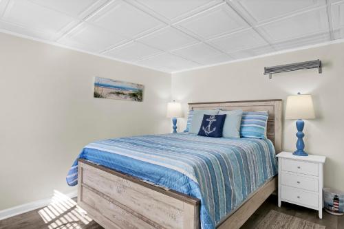a bedroom with a bed with a blue bedspread at The Waterway 406 by Sea Scape Properties in Wrightsville Beach