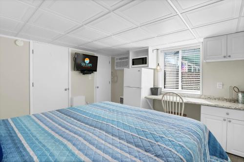 a white room with a bed and a kitchen at The Waterway 406 by Sea Scape Properties in Wrightsville Beach