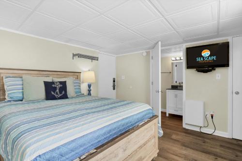 a bedroom with a bed and a flat screen tv at The Waterway 406 by Sea Scape Properties in Wrightsville Beach