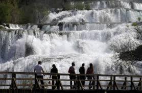 a group of people standing in front of a waterfall at Apartment Kale in Šibenik