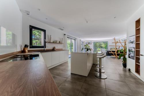 eine große Küche mit weißen Schränken und einem Tisch in der Unterkunft Vue sur parc avec pétanque, basket, clim et Tramway in Castelnau-le-Lez