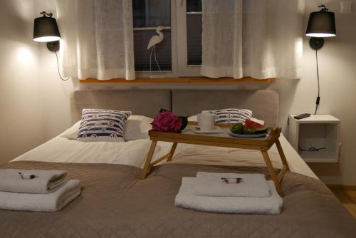 a bed with towels and a tray of food on it at Apartamenty Wakacyjne WICJAN in Chałupy