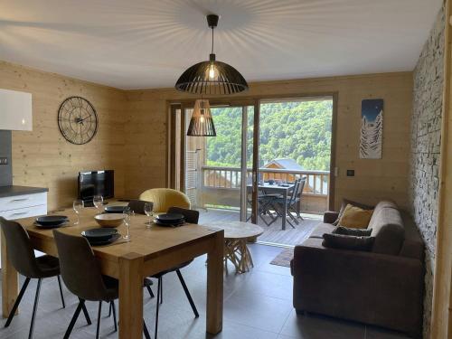 une cuisine et un salon avec une table et un canapé dans l'établissement Appartement 4 personnes de standing au coeur du village, à Saint-Sorlin-dʼArves