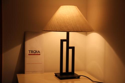 a lamp on a table next to a box at Troia Hotel in Amares